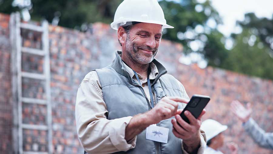 Construction worker using smartphone on site