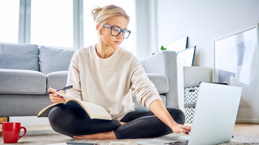 A person sitting on a couch with a laptop.