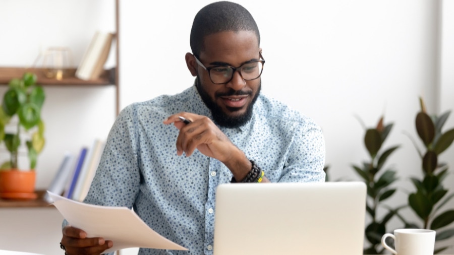 A man sitting at a desk with a laptop.