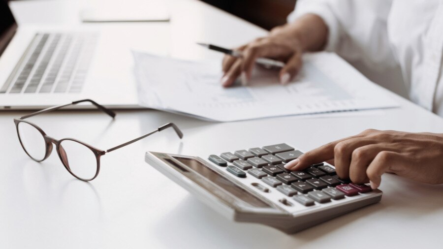 A calculator sitting on top of a table filled with papers.