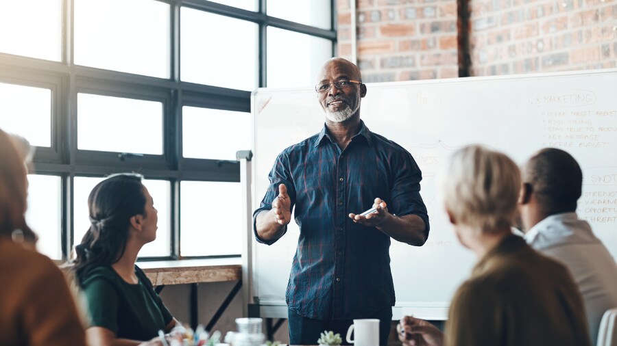 A man talking to a group of people in a room.