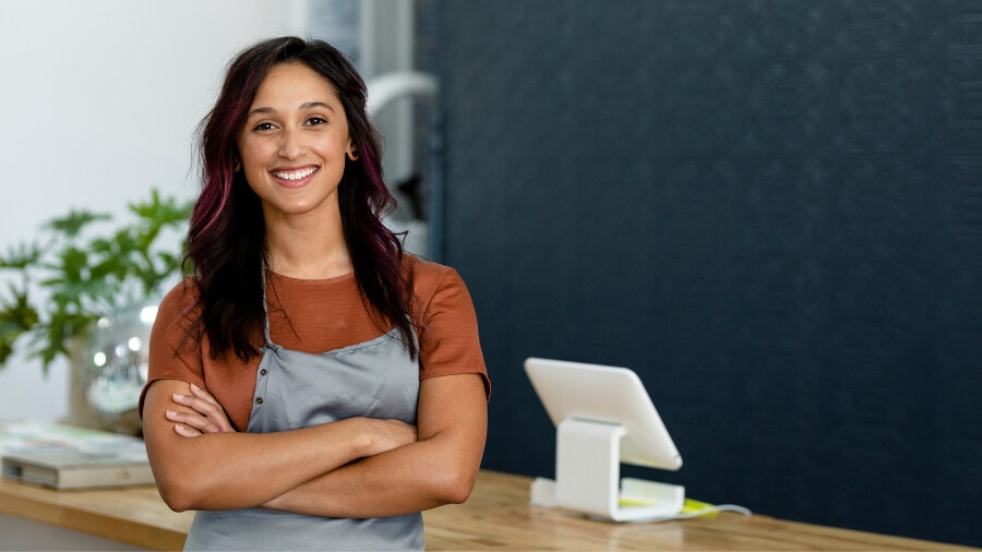 A woman in a brown shirt smiling at the camera