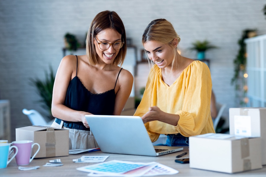 Two female business owners checking their payroll automation documents