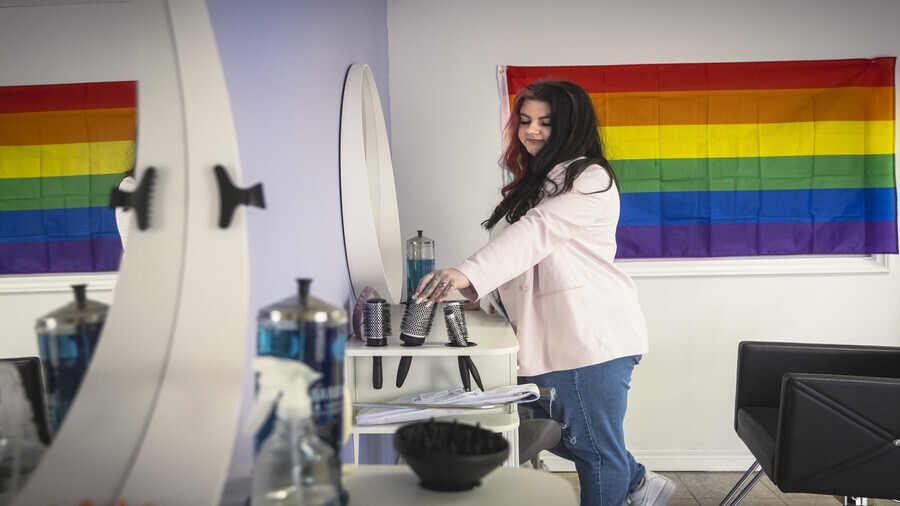 A person is holding a hair dryer in a kitchen.