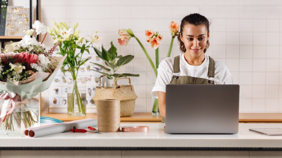 A person is sitting at a table with a laptop.