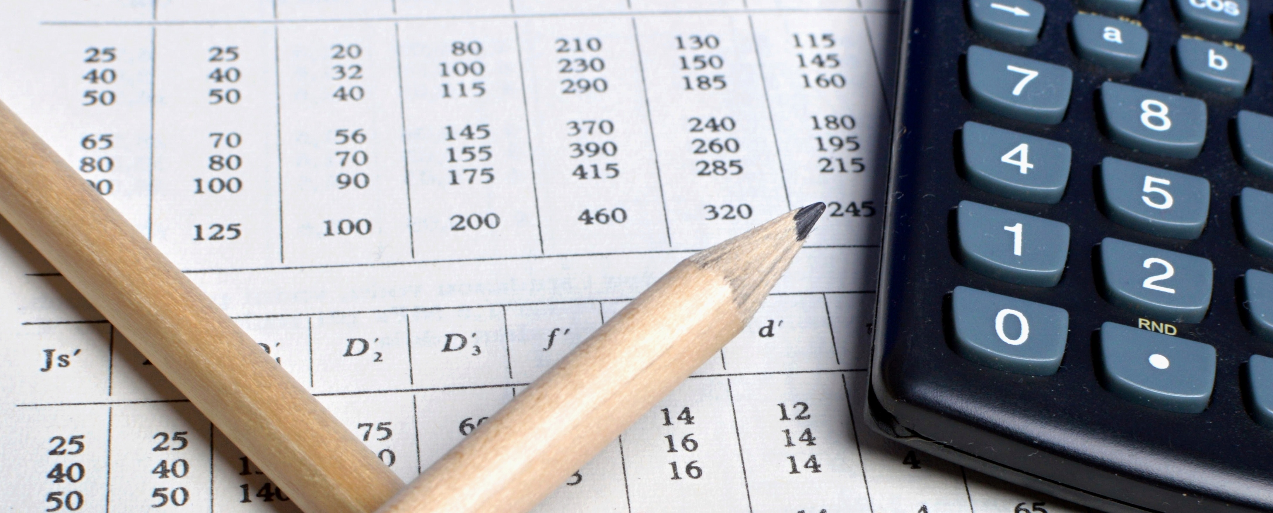 Pencil next to calculator and sheet of numbers