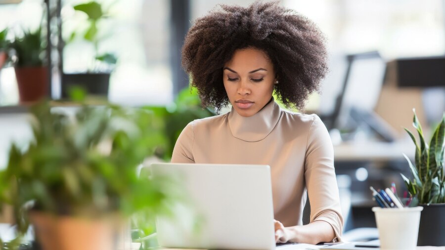 A woman sitting at a desk with a laptop.