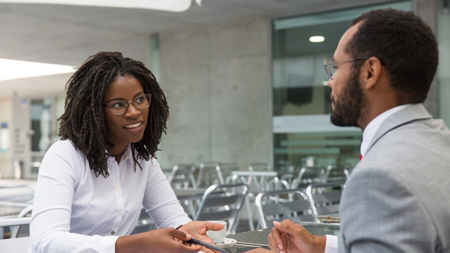 Une personne est assise à une table avec un homme.