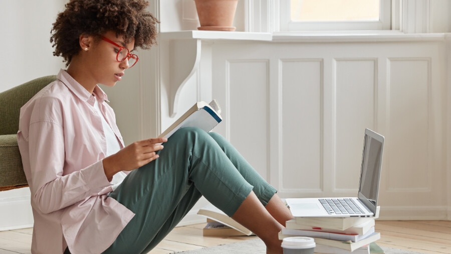 A person sitting on a chair with a laptop.