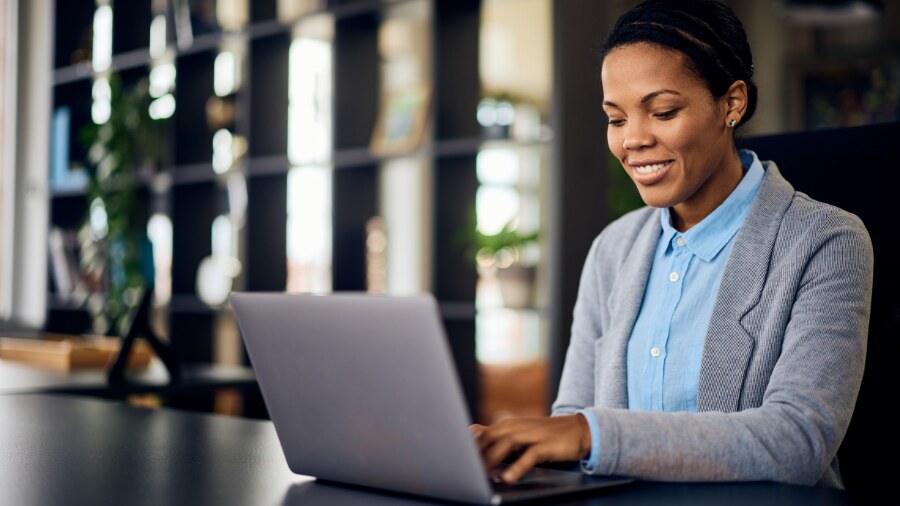 A lady typing on a laptop computer.