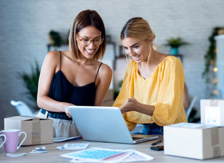 Two women discussing design with colour sheets