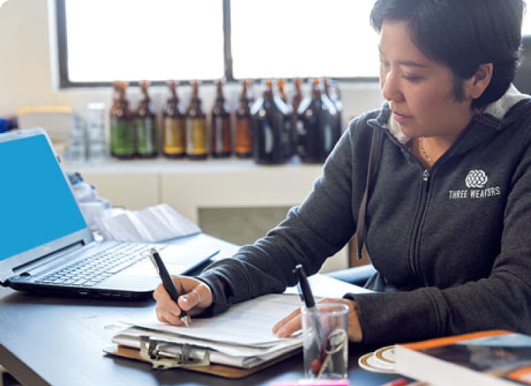 A person sitting at a table with a laptop.