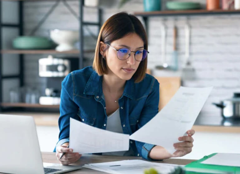 Propriétaire de petite entreprise vérifiant les factures échues à son bureau.