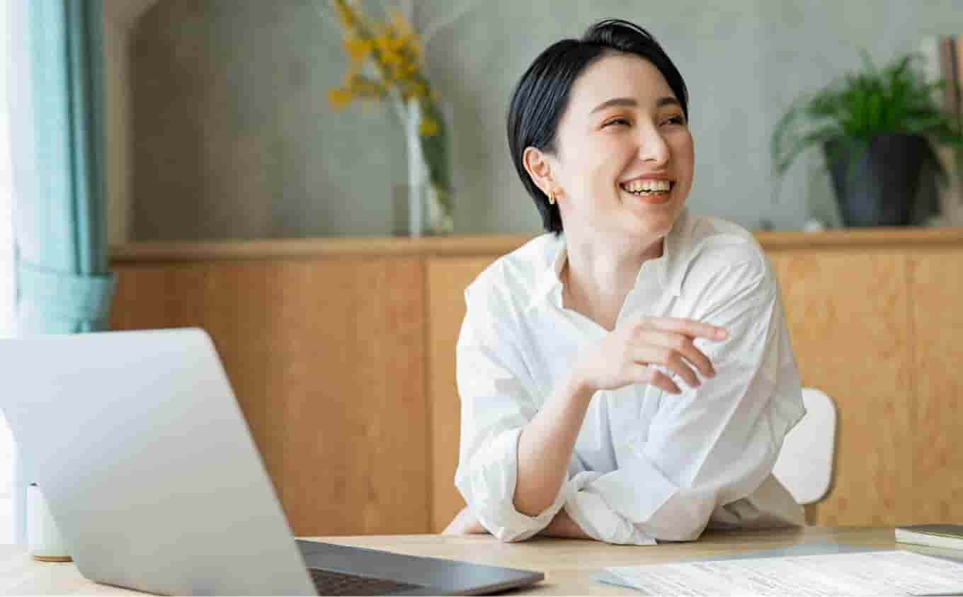 Smiling accountant sitting at desk using QuickBooks Online Accountant on her laptop.