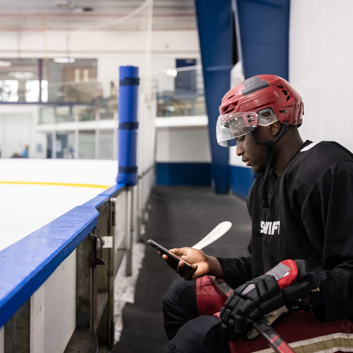 A person sitting on a bench with a hockey jersey on.