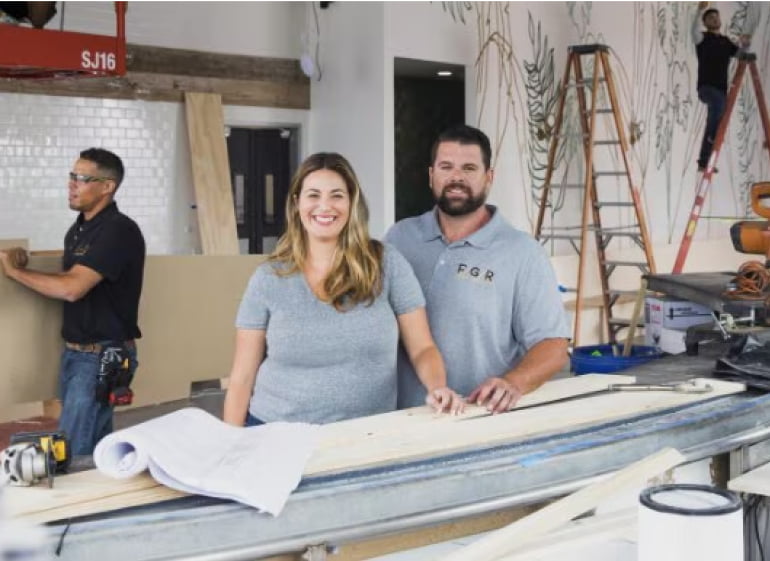 A person and person are in a shop making surfboards.