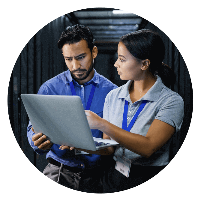 Two IT workers consult in a server room