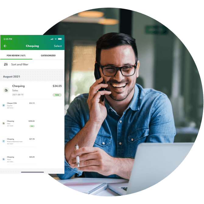 A smiling man talks on his smartphone in front of his laptop. A pop-up shows expenses for review in QuickBooks Online.