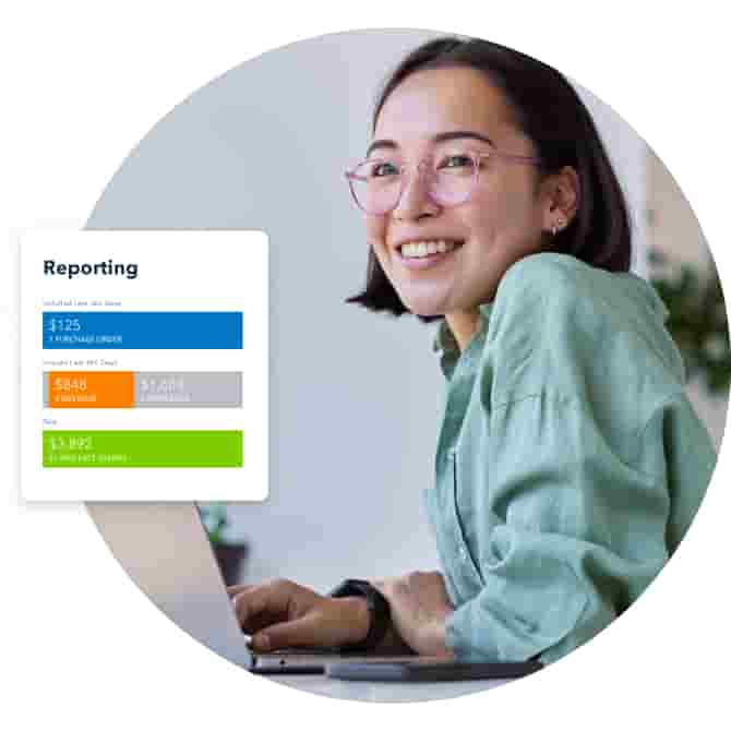 Woman looks up from her reports in QuickBooks Online on her laptop and smiles