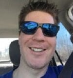 Bob Kirkey grinning in blue sunglasses