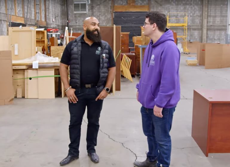 A person standing next to another person in a warehouse.