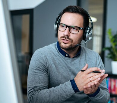 Man wearing headphones providing customer support.