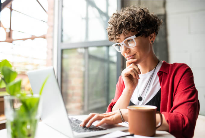 Accountant sitting by a window using QuickBooks Online Accountant on her laptop.