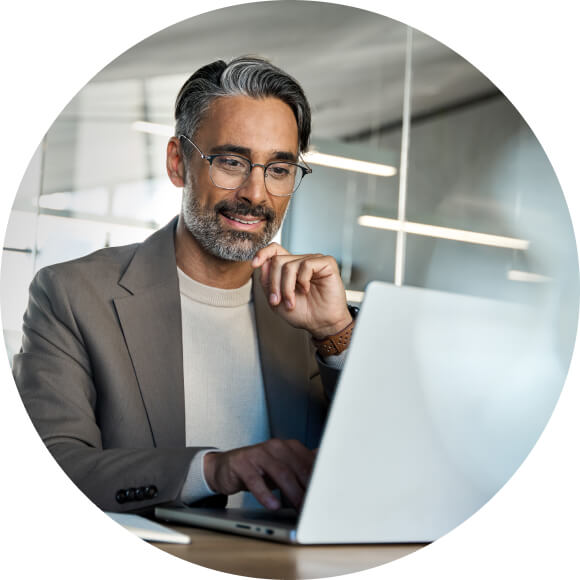 A person in glasses is holding a laptop.