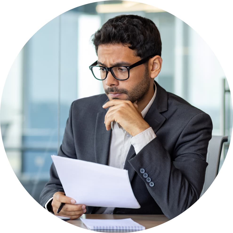 A person sitting at a desk with a laptop in front of him.