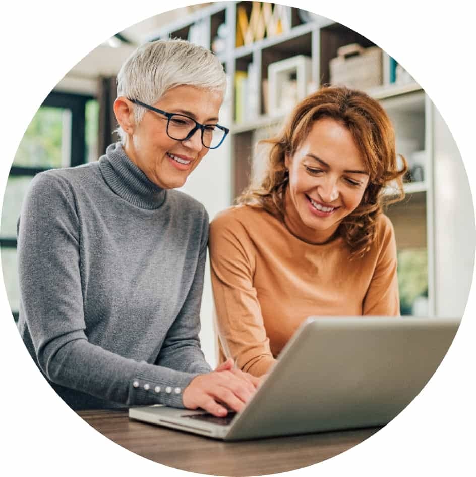 Two people sitting next to each other with a laptop.