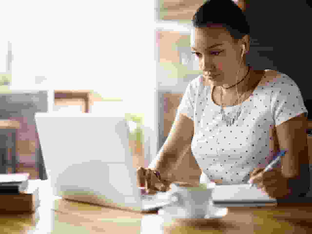 A person sitting at a table with a laptop.