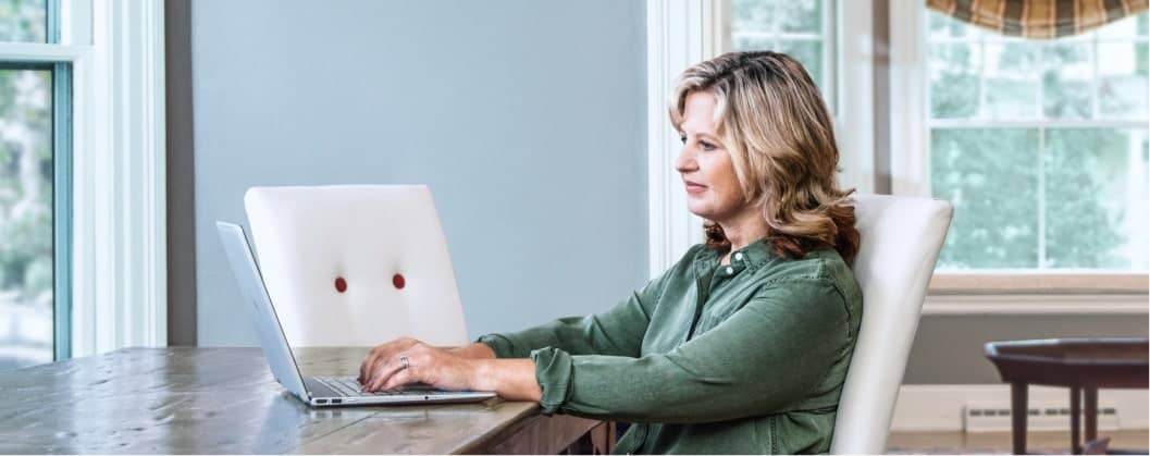 A person sitting at a desk with a laptop computer.