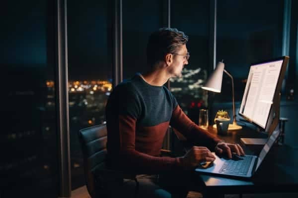 A person sitting at a desk with a laptop computer.