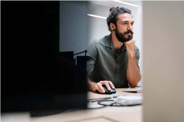 A person sitting at a desk with a laptop computer.