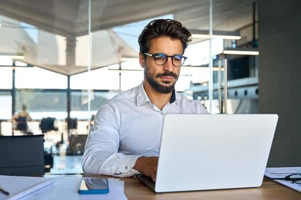 A person sitting at a table with a laptop.