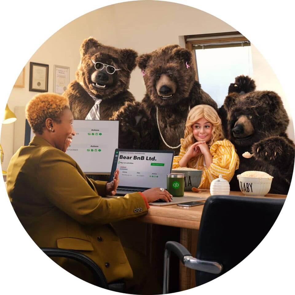 Three people sitting at a table with two bears.