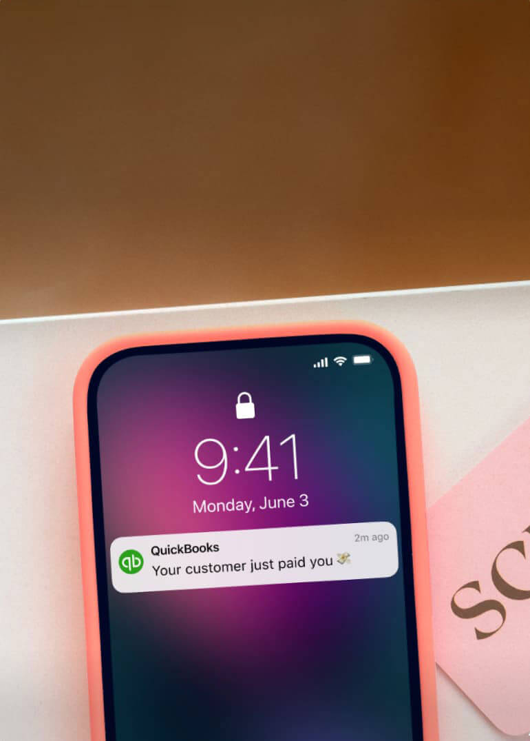 A phone with notification from QuickBooks.
