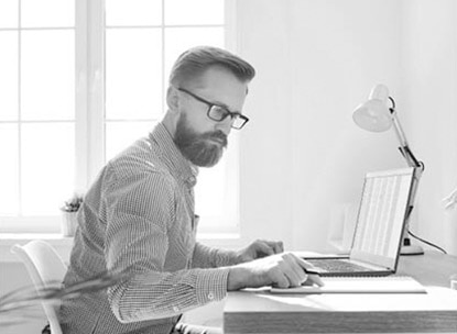 A person sitting at a desk with a laptop computer.