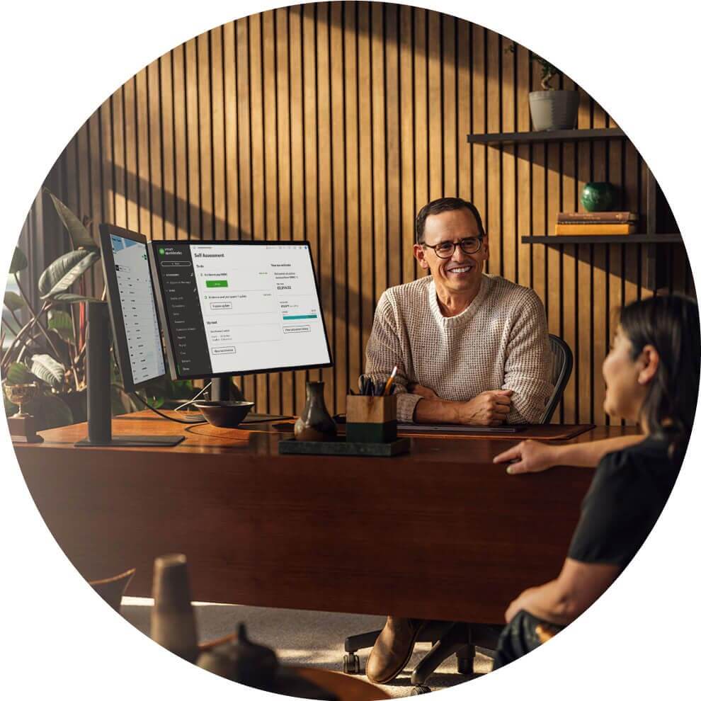 A person sitting at a desk in front of a laptop computer.