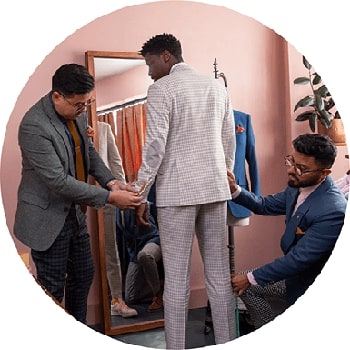 A person adjusting another man's tie in a room.