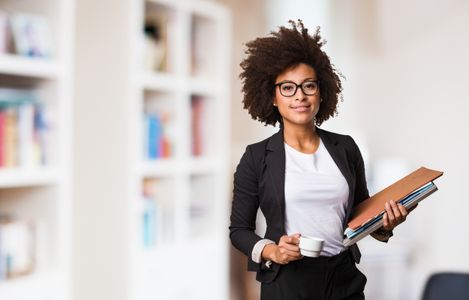 A person in a black shirt holding a laptop.