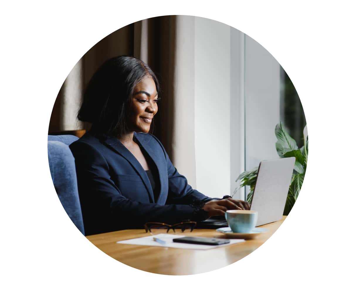 A person sitting at a desk with a cup of coffee.