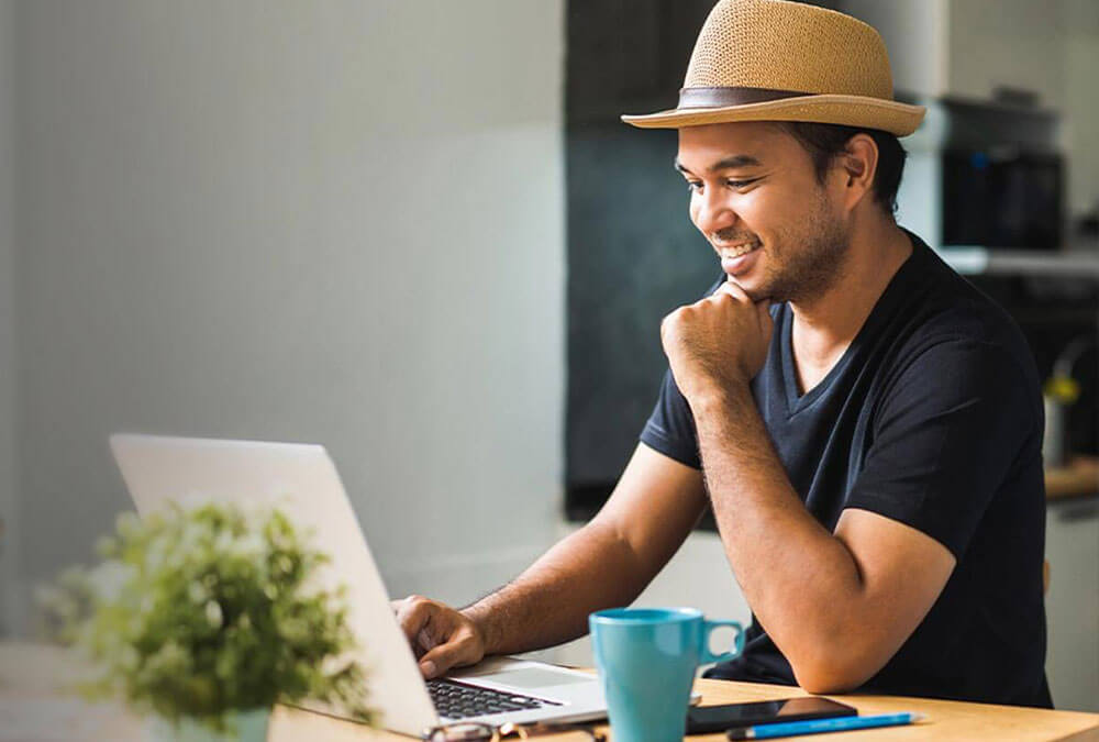 A person sitting at a table with a laptop computer.