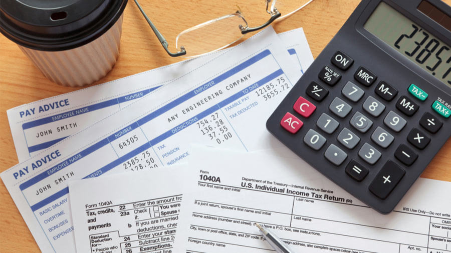 A calculator, money, and other items on a table.