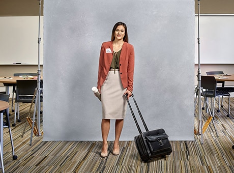 Woman being photographed holding luggage
