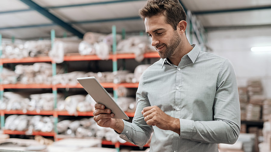 Business owner analysing inventory on tablet amongst inventory