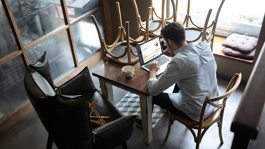 Man using QuickBooks Online accounting software on laptop in a cafe