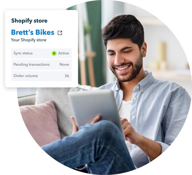 A smiling person is holding a bike with a picture of a person on it.