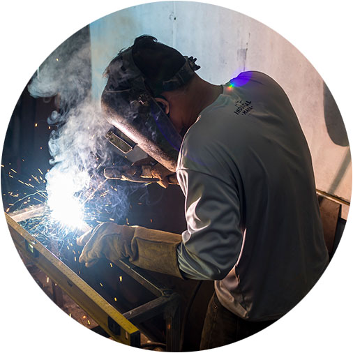 A person working on a pipe in a shop.