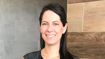 A person smiling and wearing a tie and a shirt.